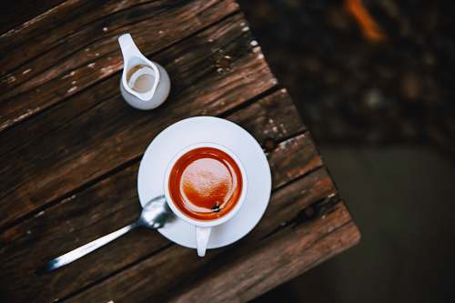 coffee mug filled with cappuccino on saucer flatlay